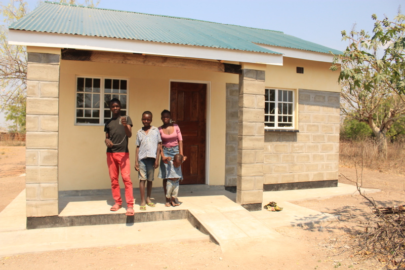 Sam og systkini hans fyrir framan nýja húsið sitt.