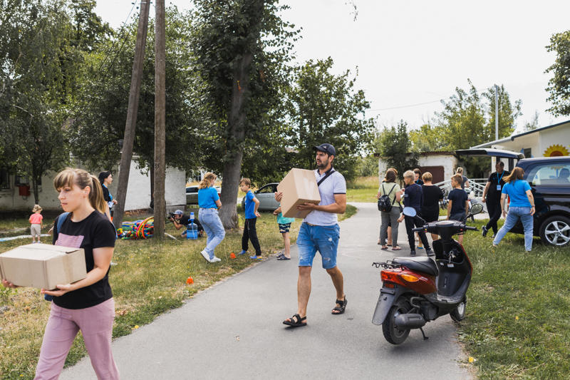 Börn, foreldrar og samstarfsfólk SOS við dreifingu hjálpargagna á Kyiv svæðinu.