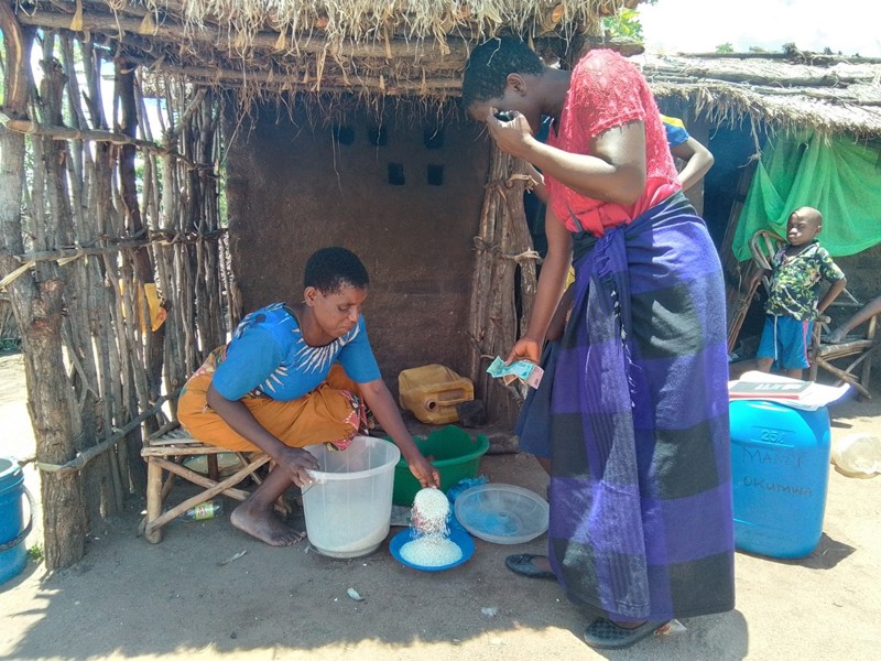 Makhaza hefur með miklum dugnaði skapað sér nokkrar tekjuleiðir með stuðningi fjölskyldueflingar okkar. Hér er hún að afgreiða hrisgrjón sem hún selur.