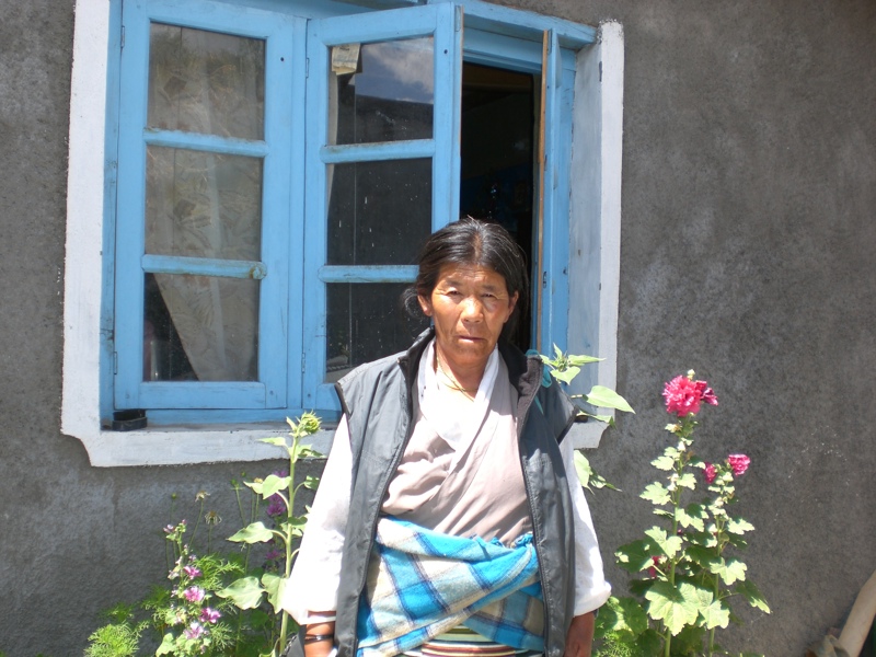 Móðir Sonam við húsið sem þau byggðu fyrir íslenskt fé.